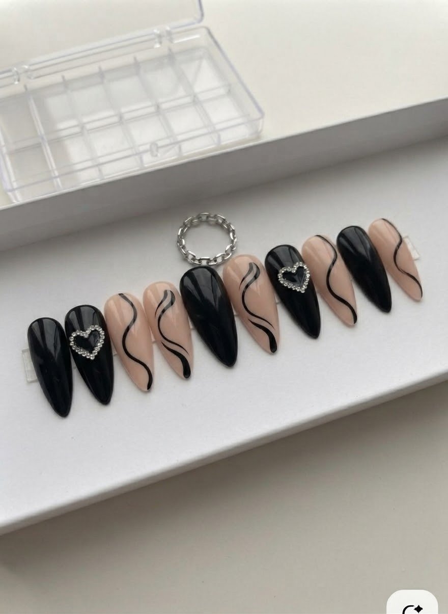 Black and nude swirl press-on nails featuring rhinestone heart charms